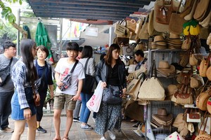 2月22日，韓籍遊客在峴港韓市場選購紀念品。（圖源：晉力）