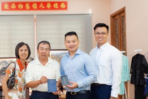 周志雄伉儷（左一、二）把其祖父的“華僑登記證”送給作者提倡的計劃。
