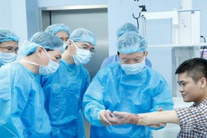 108軍隊中央醫院院長梅鴻龐教授（右二）為接受手掌移植手術後的病人檢查縫合處並評價手指伸縮機能。