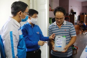 青年向人民贈送消毒洗手液。