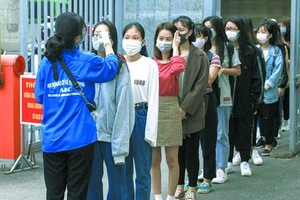 河內市所屬新聞與宣傳學院的大學生進校時接受額溫檢測。（圖源：VOV）