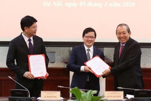 政府常務副總理張和平（右）向兩位新任司法部副部長頒授職務調任《決定》。（圖源：黎山）