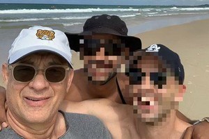 湯姆‧漢克斯(左)在海灘和影迷合影。（圖源：互聯網）