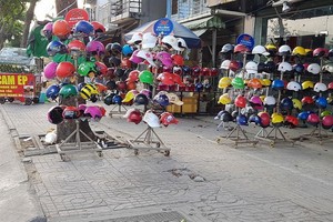 范文同街人行道上售賣廉價安全帽的攤子一瞥。