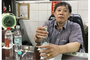鍾世強醫師示範把白酒和清水溶合動作。