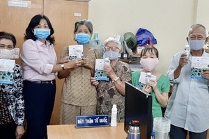 陳月梅主席（左二）向人民贈送口罩。