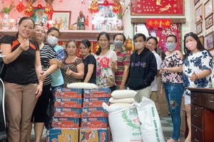 梁柳嬋(右一)與員工準備將大米和麵發送給窮人。