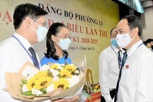 新平郡郡委書記黎黃河（右）祝賀黃文才同志聯任2020-2025年任期坊黨委書記。