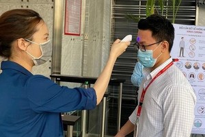 出入公寓民眾都要量體溫。（圖源：范孟）