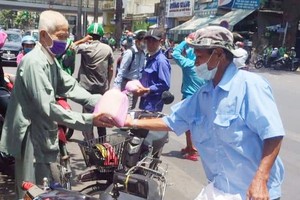 華人商販應氏蓮託“摩的”司機派發救濟品。