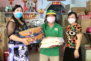 梁柳嬋（左）與弟婦向勞動人家贈送禮物。