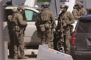 19日，在加拿大新斯科舍省，警察在一處加油站準備採取行動。（圖源：AFP）