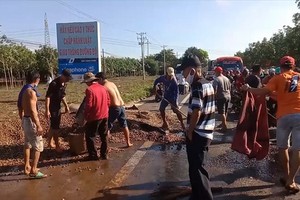 當地民眾與路人合力協助司機撿拾撒落在路面上的腰果。（圖源：PV）