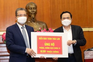 外交部副部長、旅居海外越南人國家委員會主任鄧明魁（左）向越南祖國陣線中央委員會轉贈善款。（圖源：越通社）
