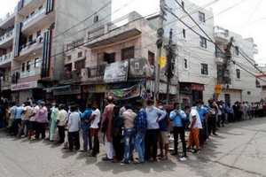 當地時間4日，成百上千人在印度首都新德里重開的各個酒舖外排起了長龍。（圖源：路透社）