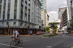 5月4日，一名男子騎自行車經過新西蘭首都惠靈頓的商業街。（圖源：新華社）