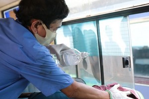 巴士服務員在車廂上清潔座椅、扶手桿、車窗等。（圖源：孟玲）