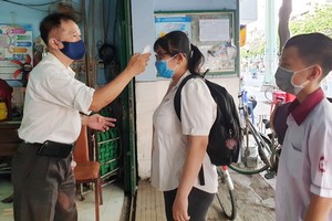 學生進校門時接受體溫測試。