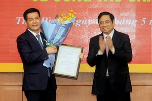 中央組織部長范明政（右）向阮鴻延同志頒授人事委任《決定》並送鮮花祝賀。（圖源：宣教部）