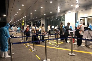 從美國加州撤回的同胞抵達廣寧省雲屯機場時辦理健康申報手續。（圖源：VNA）