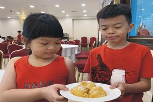 華人小朋友在愛華2大酒樓早市部品嚐蛋球沙翁。