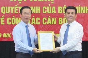 新任中央宣教部副部長阮鴻延（右）從中央宣教部長武文賞手中接過人事委任《決定》。（圖源：宣教部）