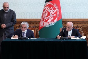 5月17日，阿富汗總統加尼（右）與競選對手、前政府首席執行官阿卜杜拉在總統府簽署權力分配協議。（圖源：新華社）