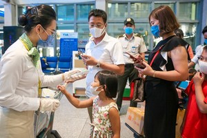 乘務員為乘客檢測體溫。（圖源：Zing）