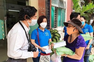 《西貢解放報》社會慈善-讀者工作組人員在抗疫期間向受影響的民戶派發輔助現金、大米和日需品。（圖源：孟和）