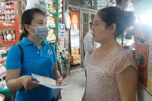 郵政局人員為第一郡德河街市商販諮詢社保政策。（圖源：阮賢）