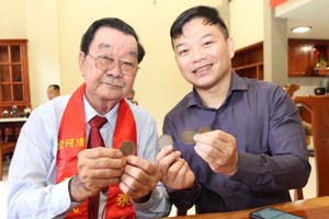 張興盛先生（左）向“西堤華人文化陳列室”成立計劃捐贈古銀元。