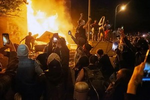 5月28日，在美國明尼蘇達州明尼阿波利斯市，示威者點燃一警察局。（圖源：新華社）