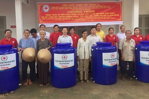 第五郡紅十字會和穗城、溫陵會館代表向貧戶移交水塔。