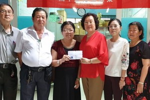 禮文華文中心校長許少蘭向家境貧困老師發補助額。