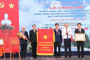 受國家主席的委託，政府常務副總理張和平向州城縣黨部、政府和人民頒授三等勞動勳章。（圖源：越通社）