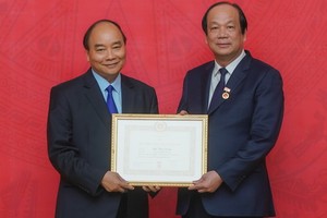 政府總理阮春福（左）向黨中央委員、政府辦公廳黨委書記、辦公廳主任梅志勇部長頒授40年黨齡紀念章。（圖源：光孝）