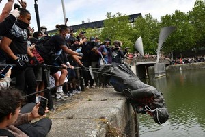 示威者用繩索拽倒了愛德華‧科爾斯頓的銅像，對其進行塗鴉、踩踏，並將其淹入河中。（圖源：互聯網）