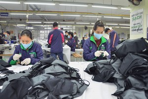 激發企業內在力量以恢復經濟。 圖中：太原TNG公司縫製出口口罩。