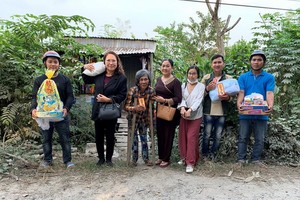 葉日長（右二）與萬德慈善俱樂部成員們向貧民贈送禮物。