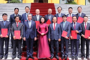 國家副主席鄧氏玉盛（前中）與12位新任越南駐外國大使在主席府前合照。（圖源：越通社）