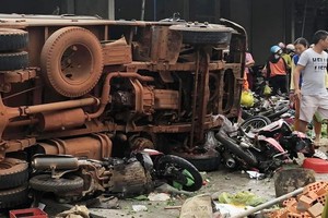 肇事卡車衝進路邊街市後側翻。