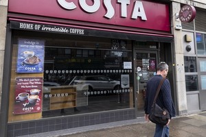 6月10日，行人經過英國倫敦一家仍然關閉的咖啡館。 （圖源：新華社）