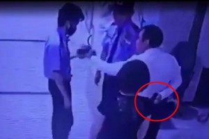 監控視頻截圖畫面顯示 L.X.T拿出疑似手槍物體（紅圈示）威脅並抓住大廈保安員孔志雄頭髮。