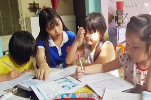 共青團團員給少兒輔導功課。（圖源：黎維）