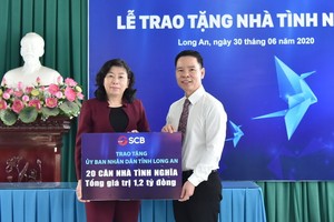 丁文成董事長(右)將善款轉交隆安省人委會代表。