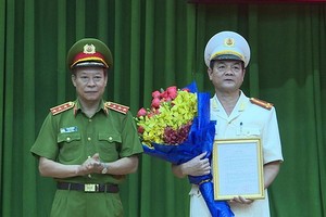 公安部副部長黎貴王向黎鴻南大校（右）頒發人事委任《決定》並送祝賀鮮花。（圖源：H.T）