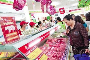 消費者在超市選購豬肉。（圖源：越勇）