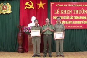 廣南省公安廳代表（中）向 2名取得出色成績的民兵隊員頒授獎狀。（圖源：明俊）