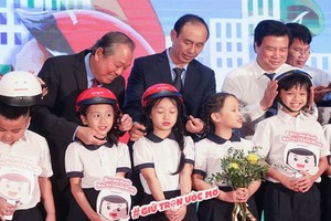 張和平副總理（後左一）出席“圓夢”活動並親切為小學生扣上安全帽。（圖源：教育部）