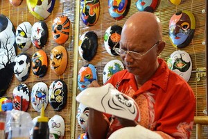 裴貴峰用心繪畫每一張面具。